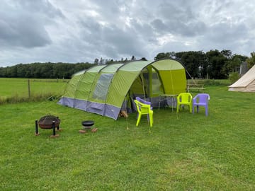 Pre-pitched tent sleeping four, with camp beds and a table and chairs