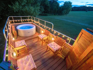 The roof deck and hot tub lit up at night