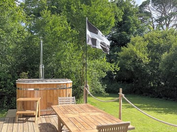The private decking area, outdoor furniture and wood fired hot tub.