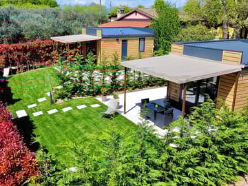 Spazio esterno dell'alloggio: veranda arredata e giardino privato