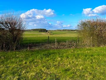 View through a window in the campervan field across the vehicle free field and beyond