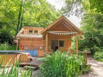 Front view of tawny cabin with wood fired hot tub
