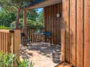 Covered terrace with wooden table and barbecue
