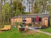 Snowy lodge with outdoor seating and hot tub