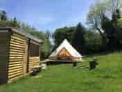 The bell tent kitchen and firepit on a sunny day