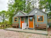 Outside of luxury pod with TV , fridge, kettle, couch, microwave