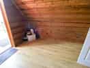 Other side of living room with just a fridge with kettle on top