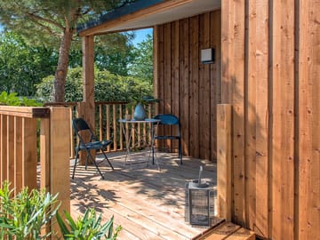 Covered terrace with wooden table and barbecue