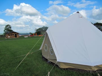 A large tent with the site office in the background