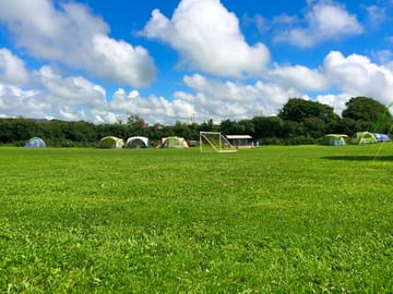 Family camping field allows parents to watch their children play safely from comfort of their tents.