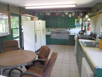 Base camp kitchen with pots, pans, dishwasher, indoor propane grill and stove/oven, 3 refrigerators