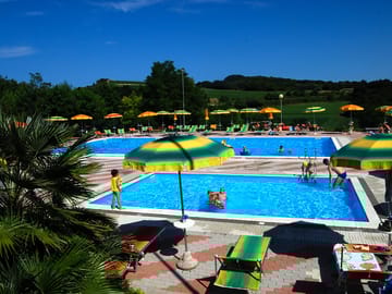 Swimming pool and paddling pool with deck chairs and sun loungers