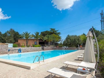 Swimming pool with sun loungers and umbrellas