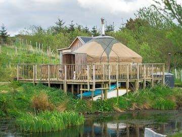 The decking is on stilts at the edge of the pond
