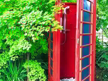 Hot shower in converted telephone box in the garden