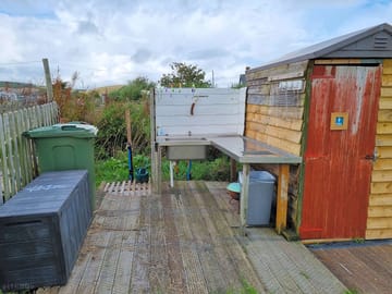 Dishwashing sink with cold water, bins, drinking water and borrow and donate box