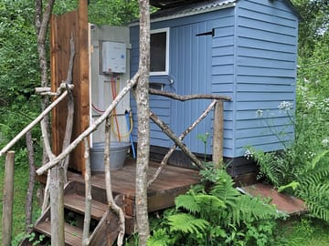 Bathroom hut at geodome with gas-powered hot water shower
