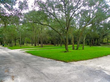 Paved roads to level gravel sites, separated by grassy areas with trees