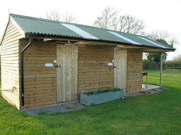 Toilets, showers and washing up area with fridge and freezer