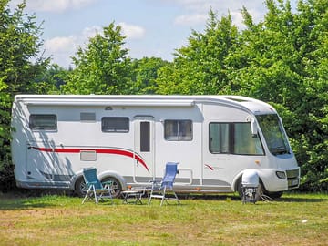 Grass pitches surrounded by trees for shade