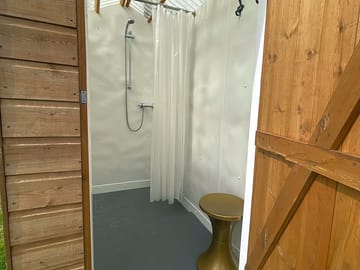 Shower showing stool and ample hooks for your clothes, towel and bag.