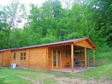 Wooden lodge surrounded by trees and grass