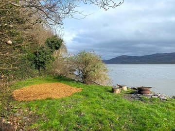 Last pitch along path, Angell. A soft wood chip patch for tent and surrounded by grass and shrubs