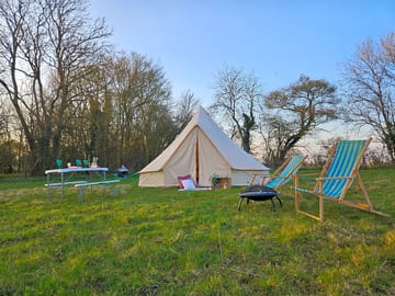 Bell tent with campfire and outdoor seating