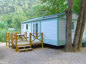 Holiday home with a wooden terrace and outdoor furniture