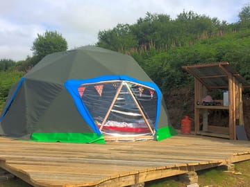 Outside of geodome with small outside kitchen
