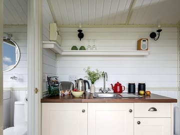 Kitchen area with sink, kettle, toaster, fridge and microwave