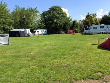 Camping field sheltered by trees