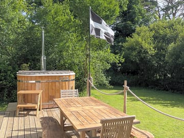 The private decking area, outdoor furniture and wood fired hot tub.