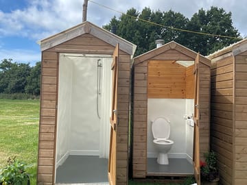 Four hot water showers and flushing loos. with festoon lighting overhead that illuminates the huts