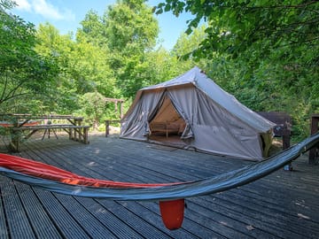 Bamboo safari tent, featuring a picnic bench and 2 hammocks