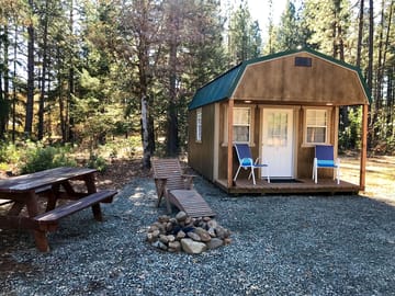 Each mini cabin has its own set of chairs, picnic table and firepit