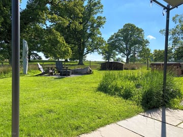 Firepit and barbecue spot with chairs made from whisky barrels