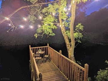 Private decking over pond at night.