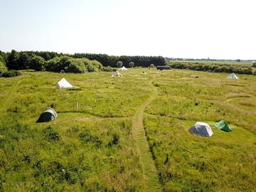 The camping meadow at the big sky hideaway in lincolnshire. grass pitches mowed into longer grass