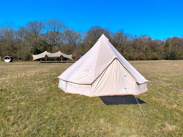 Bell tent with communal stretch tent and sauna in the background