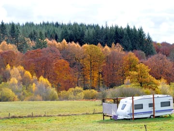 On-site touring caravan with an autumnal backdrop