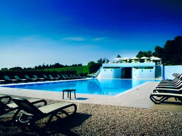 Swimming pool surrounded by sun loungers