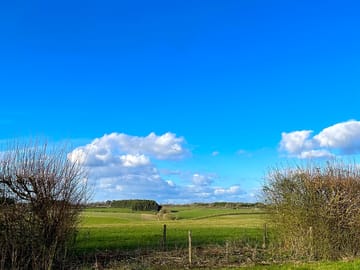 View through a window in the campervan field across the vehicle free field and beyond