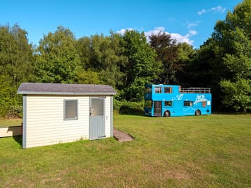 Shepherd's hut with toilet and shower facilities next to the bus