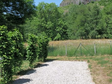 Levelled motorhome pitch, part gravel and part gras with views of the volcano