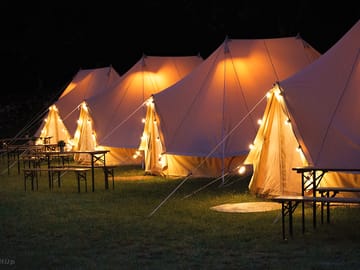 Bell tents lit up at night