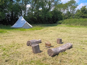 Bell tent and log seating area