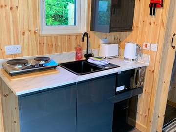 Kitchen with microwave, fridge, hob and kettle
