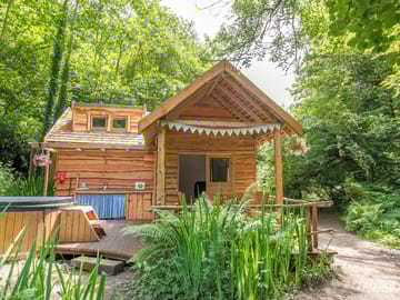 Front view of tawny cabin with wood fired hot tub