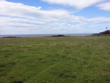 Main field of the site is flat with views across the bay